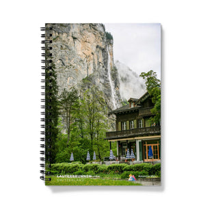 a spiral notebook with a mountain in the background