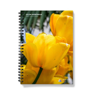 a spiral notebook with yellow flowers on a white background