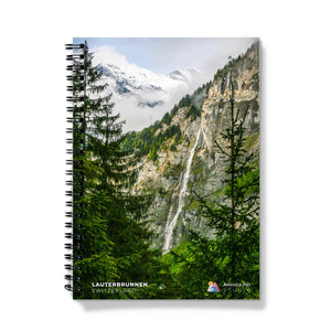 a spiral notebook with a picture of a waterfall in the mountains
