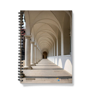 a spiral notebook with columns and arches on a white background
