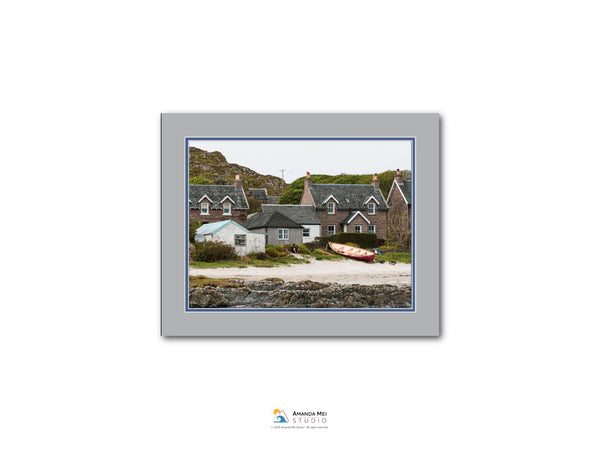 a picturesque village with quaint houses and a small boat on the shore, set against a backdrop of lush greenery and rolling hills.