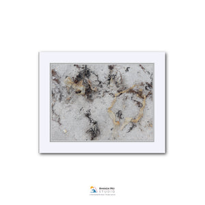 The image is a photograph of a sandy beach with various textures and patterns, including small rocks and shells.