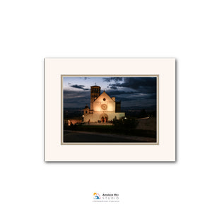 a church with a clock tower, illuminated at night against a dark sky.