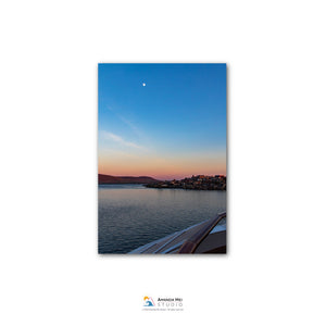 a serene sunset over a body of water, with a boat visible in the foreground.