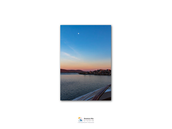 a serene sunset over a body of water, with a boat visible in the foreground.