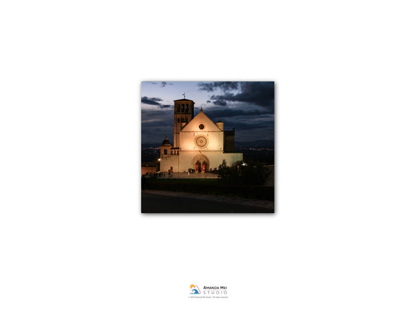a large, ornate church with a bell tower, illuminated at night against a dark sky.
