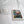 a white square frame with a photograph of a fishing net inside, placed on a white bedspread.