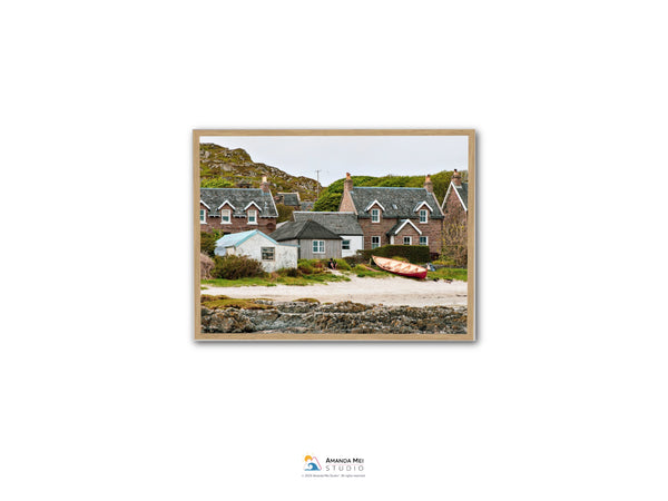 a picturesque coastal village with quaint houses, a small boat on the beach, and lush greenery surrounding the area.