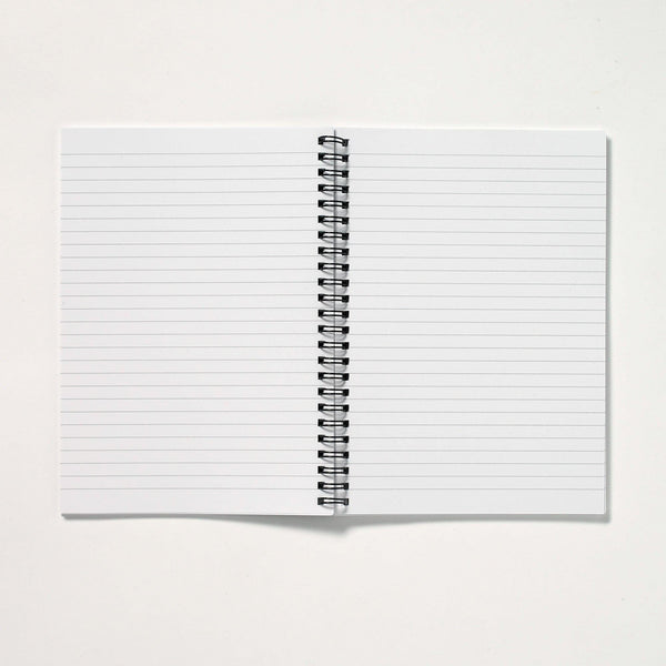 a spiral notebook is open on a white surface